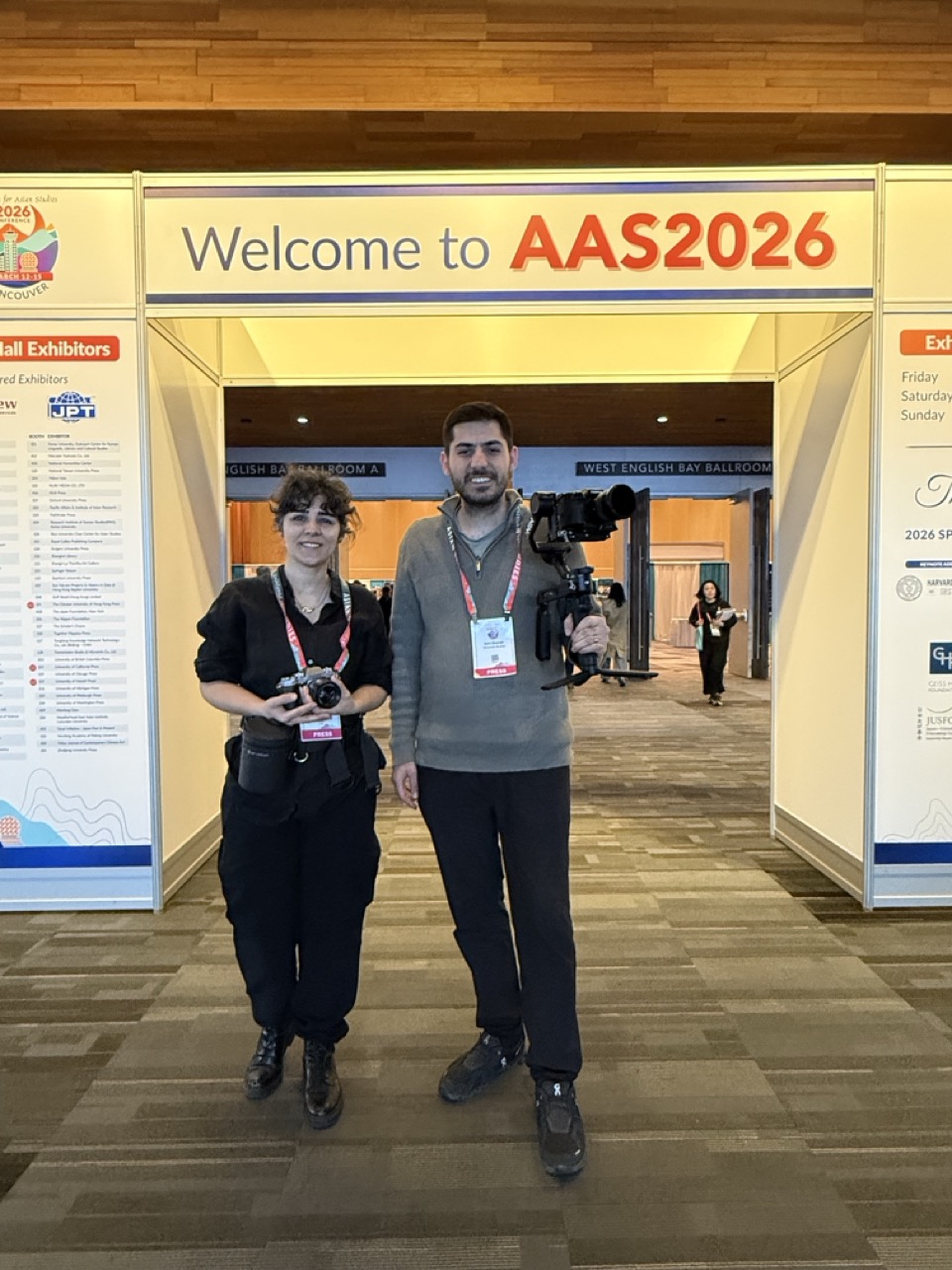 Two of the crew with press passes at a conference entrance